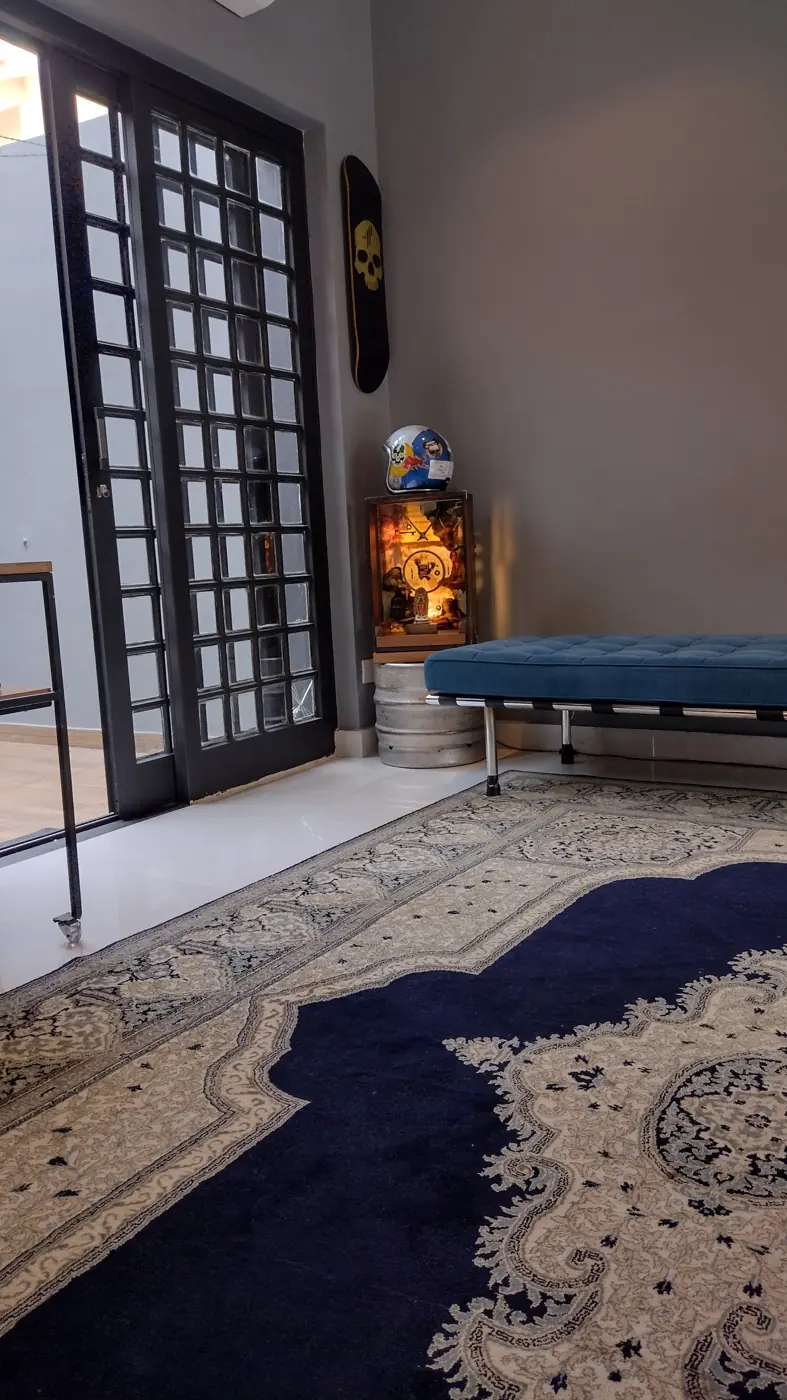 Entrada do estúdio com portas de vidro e o tapete azul