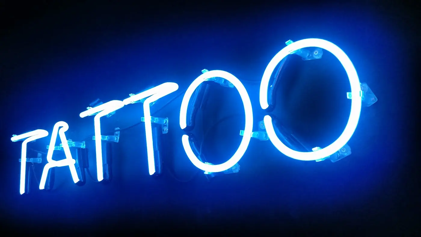 Letreiro neon azul escrito Tattoo